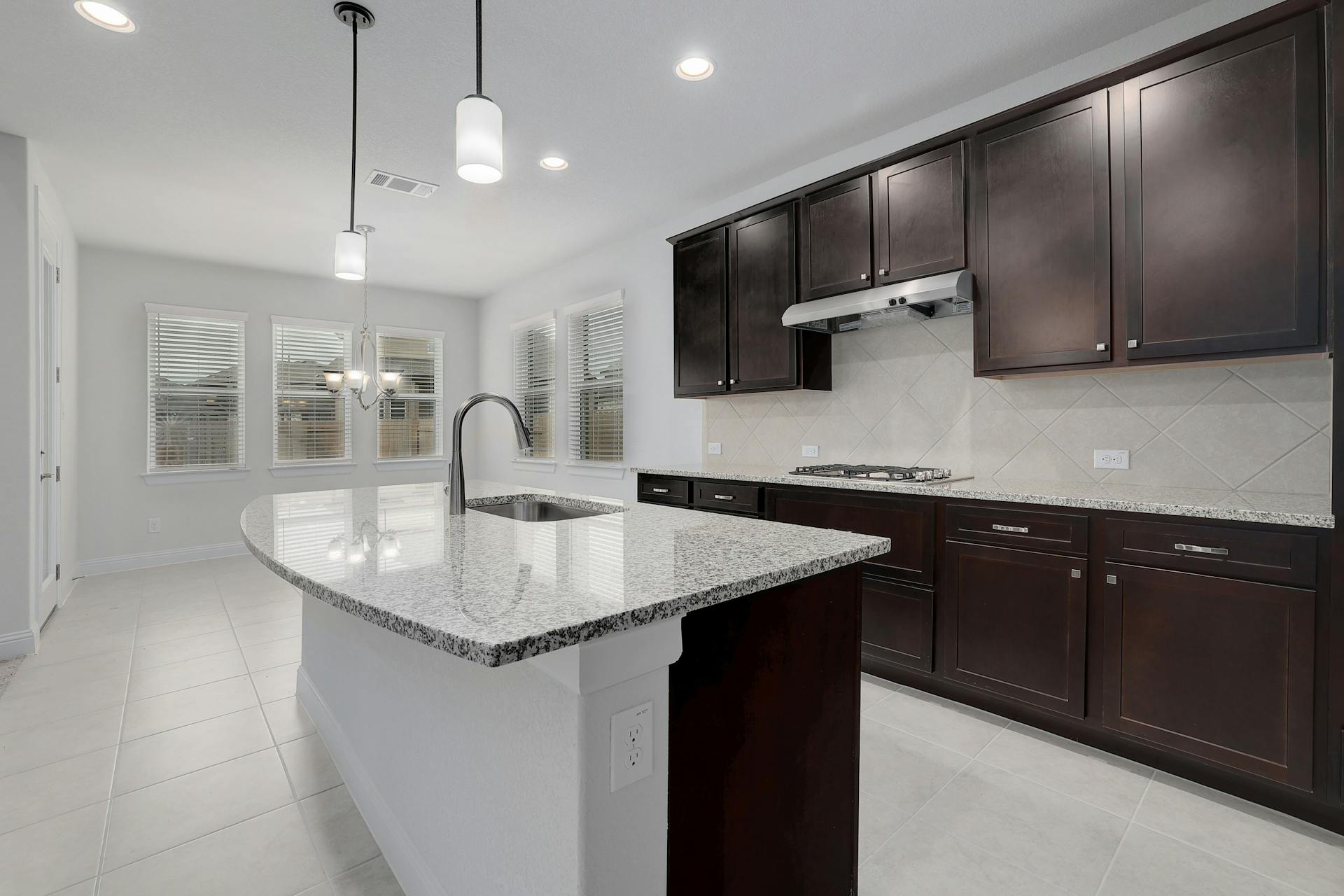 2040 Base Burner Path Leander, TX 78641 - Photo 10 of 31 Kitchen with light tile patterned floors, light stone countertops, an island with sink, and suspended lighting