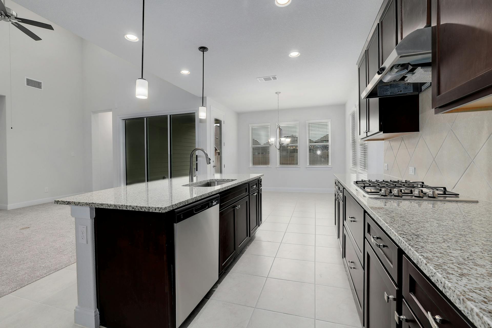 2040 Base Burner Path Leander, TX 78641 - Photo 11 of 31 Kitchen featuring light stone counters, stainless steel appliances, a chandelier, light tile patterned floors, and lofted ceiling