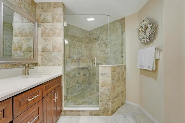 a bathroom with a granite countertop sink a shower and a mirror