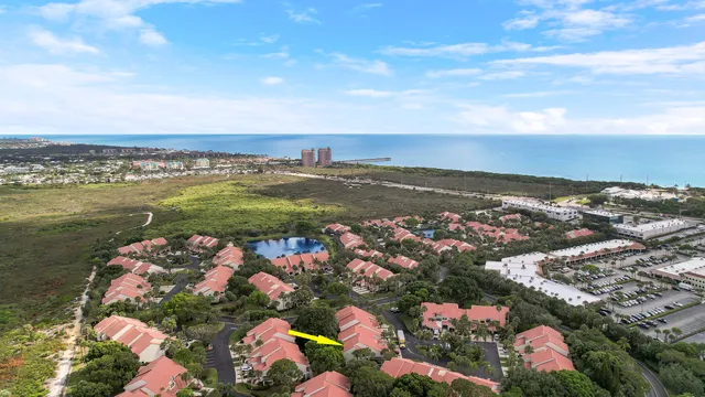 an aerial view of ocean and residential houses with outdoor space