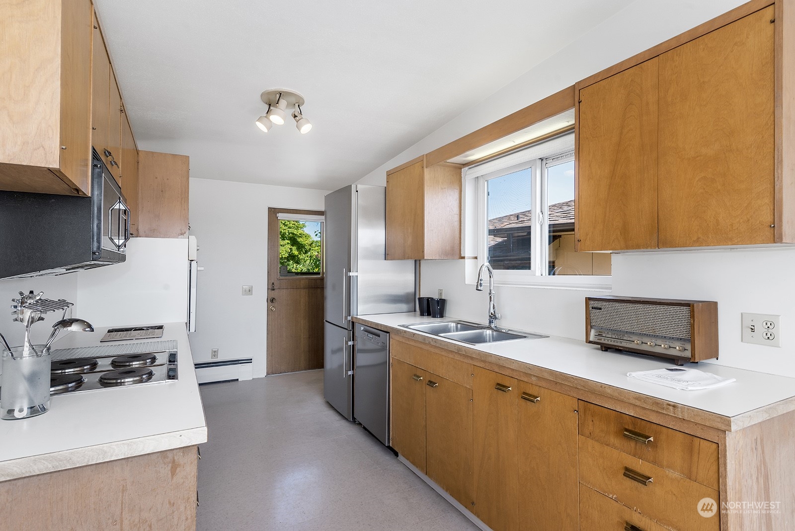 3513 West Howe Street Seattle, WA 98199 - Photo 12 of 39 a kitchen with a sink a stove and cabinets