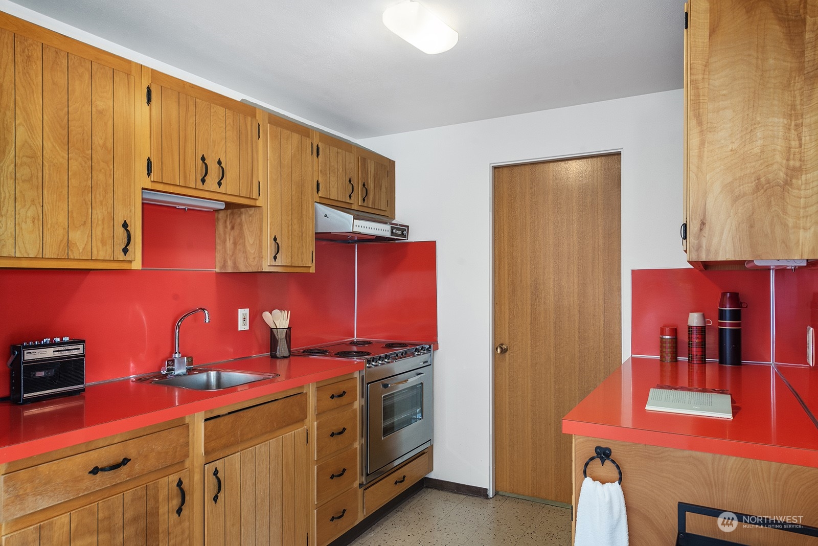 3513 West Howe Street Seattle, WA 98199 - Photo 23 of 39 a view of a kitchen with stainless steel appliances granite countertop a stove and a refrigerator