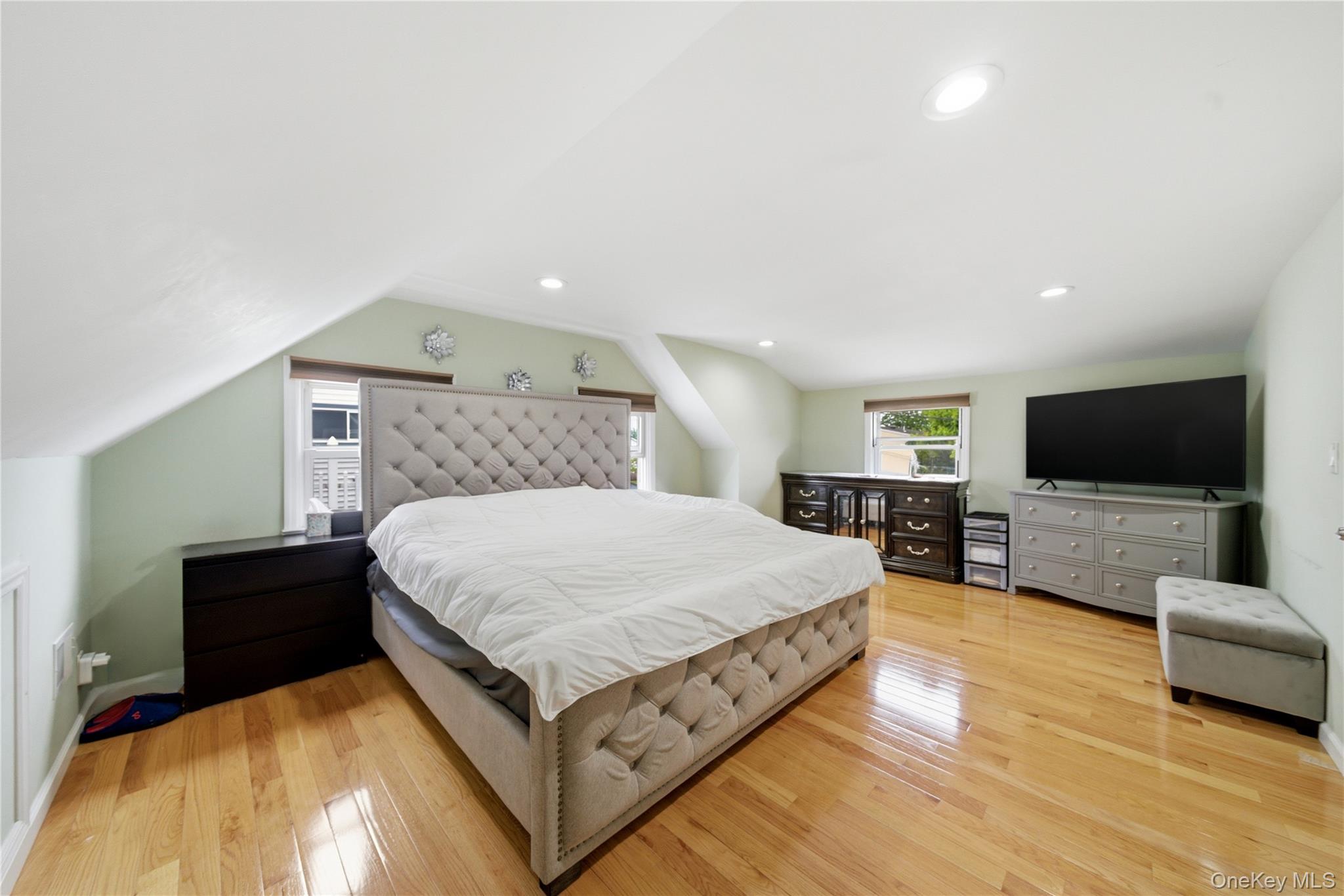 50 Ridge Lane Levittown, NY 11756 - Photo 17 of 27 a spacious bedroom with a bed and a flat screen tv