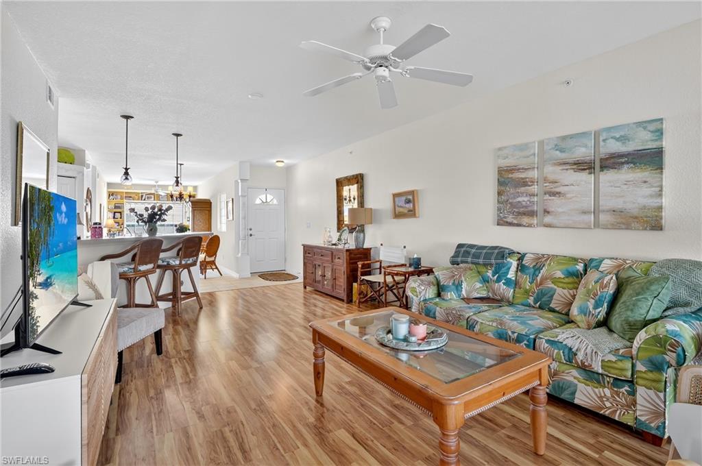 23800 Costa Del Sol Road, Unit 102 Estero, FL 34135 - Photo 6 of 49 a living room with furniture and a flat screen tv