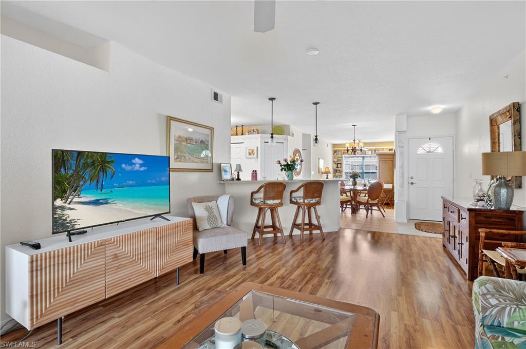 23800 Costa Del Sol Road, Unit 102 Estero, FL 34135 - Photo 7 of 49 a living room with furniture and a flat screen tv