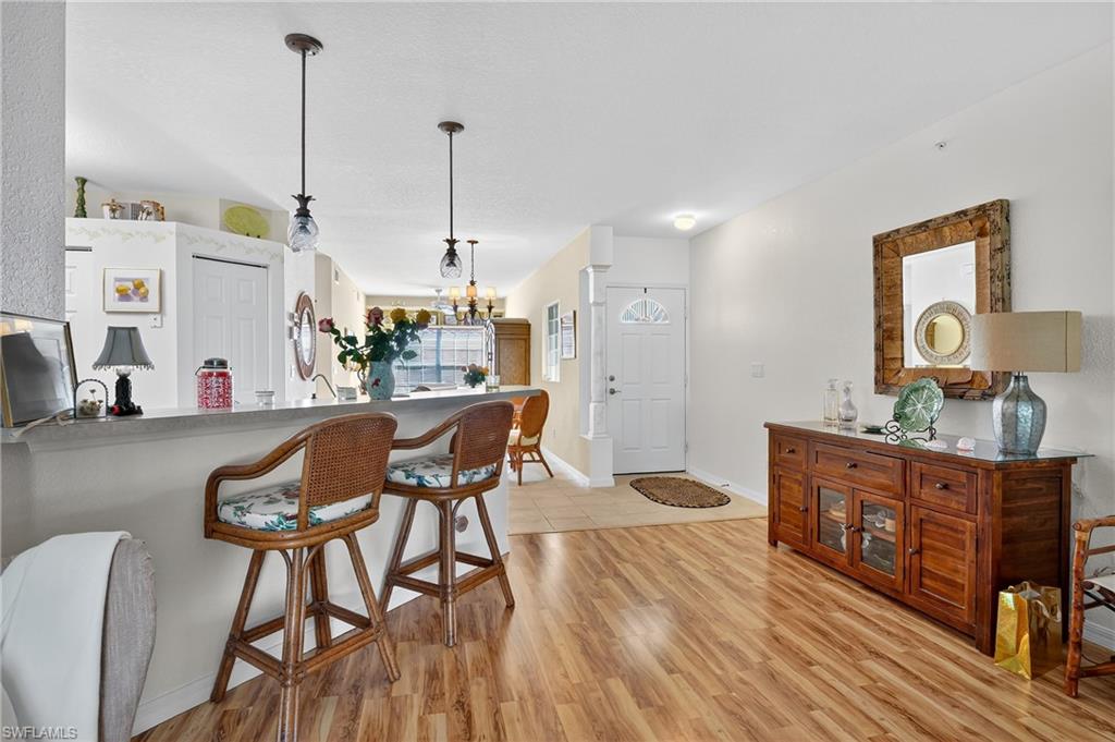 23800 Costa Del Sol Road, Unit 102 Estero, FL 34135 - Photo 8 of 49 a living room with furniture and a wooden floor