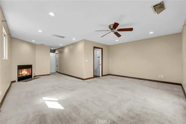 an empty room with windows and ceiling fan