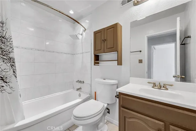 a bathroom with a sink toilet vanity and shower