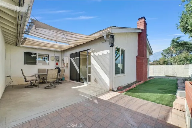 a view of a patio with a table and chairs under an umbrella