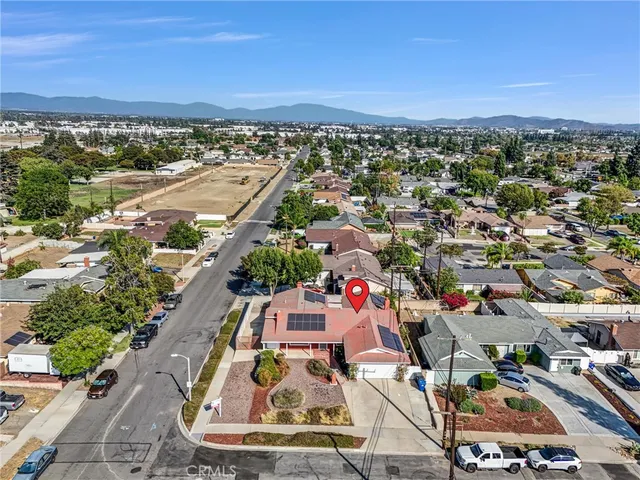 an aerial view of a city with lots of residential buildings and mountain view in back