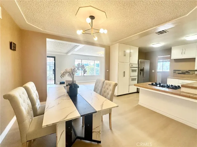 a living room with furniture kitchen view and a wooden floor