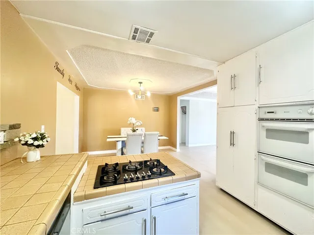 a kitchen with a stove and white cabinets
