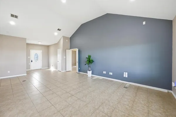 an empty room with kitchen and windows