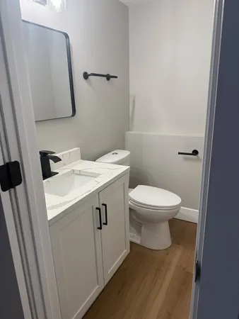 a bathroom with a toilet sink and mirror