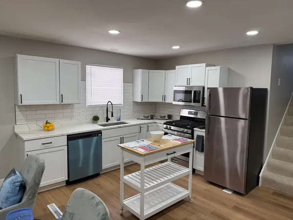 a kitchen with stainless steel appliances granite countertop a refrigerator stove microwave and sink
