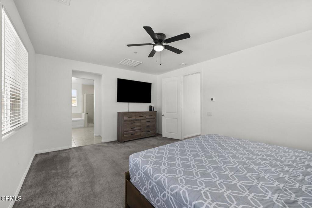 151 Rose Street Fillmore, CA 93015 - Photo 23 of 49 a spacious bedroom with a bed and a flat screen tv