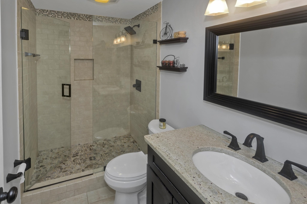 70 Corey Colonial, Unit 70 Agawam, MA 01001 - Photo 15 of 23 a bathroom with a granite countertop sink a toilet and shower