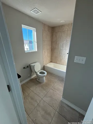 a bathroom with a toilet and a bathtub