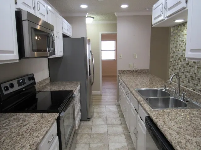 a kitchen with a sink stove and refrigerator
