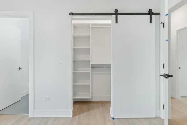 a view of walk in closet with empty racks