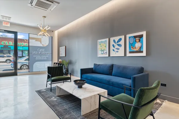 a living room with furniture a flat screen tv and a floor to ceiling window