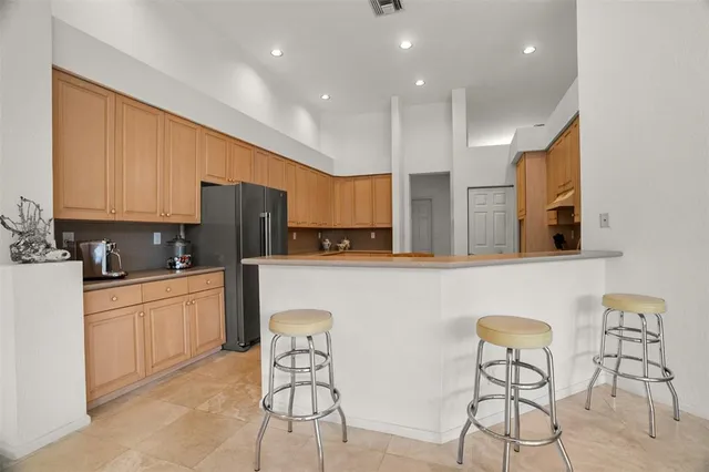 a large kitchen with stainless steel appliances granite countertop a refrigerator and a stove top oven