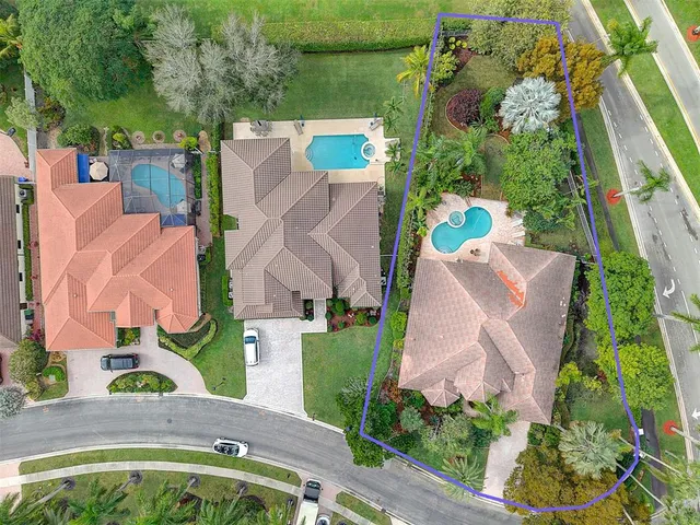 an aerial view of a house with a yard and a large pool
