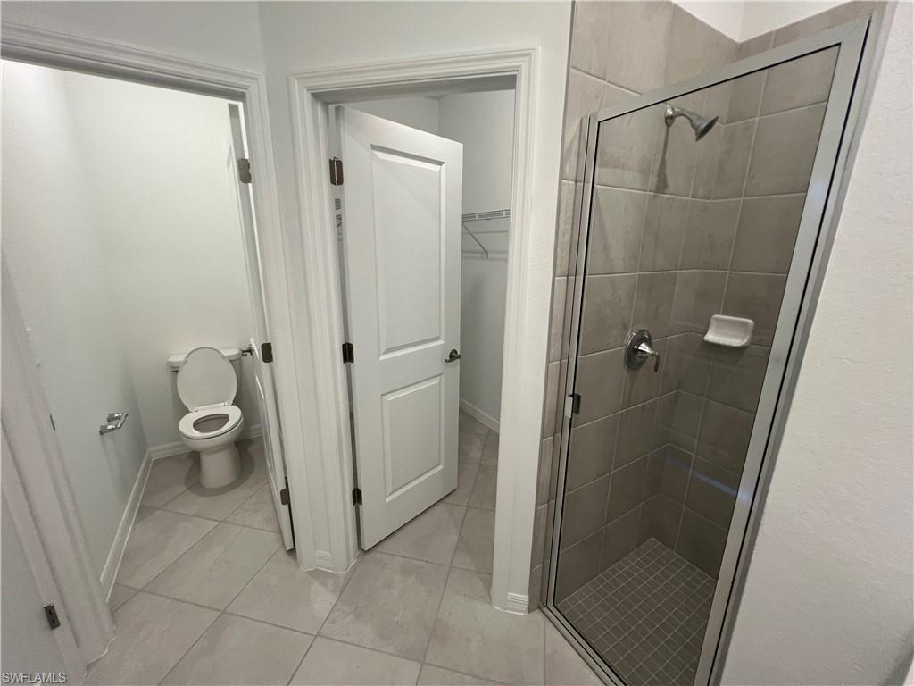 2320 Dragonfruit Way Naples, FL 34120 - Photo 19 of 33 Full bathroom with baseboards, toilet, and a shower stall