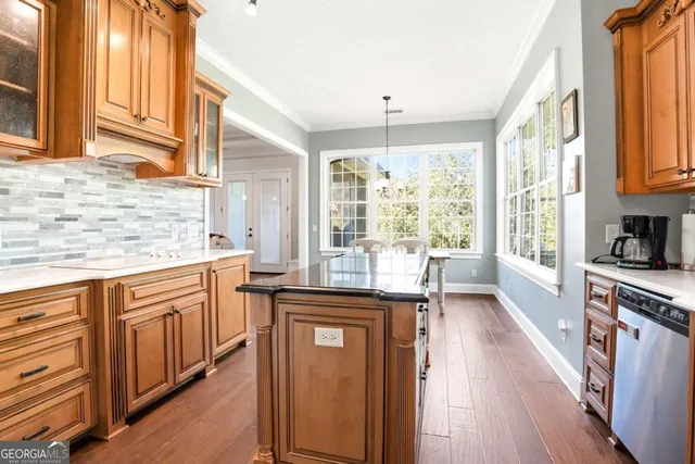 a kitchen with stainless steel appliances granite countertop a stove a sink dishwasher and a refrigerator with wooden floor