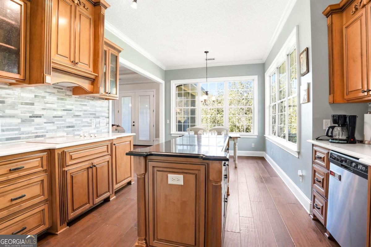 135 Stewart Street St. Simons, GA 31522 - Photo 11 of 27 a kitchen with stainless steel appliances granite countertop a stove a sink dishwasher and a refrigerator with wooden floor