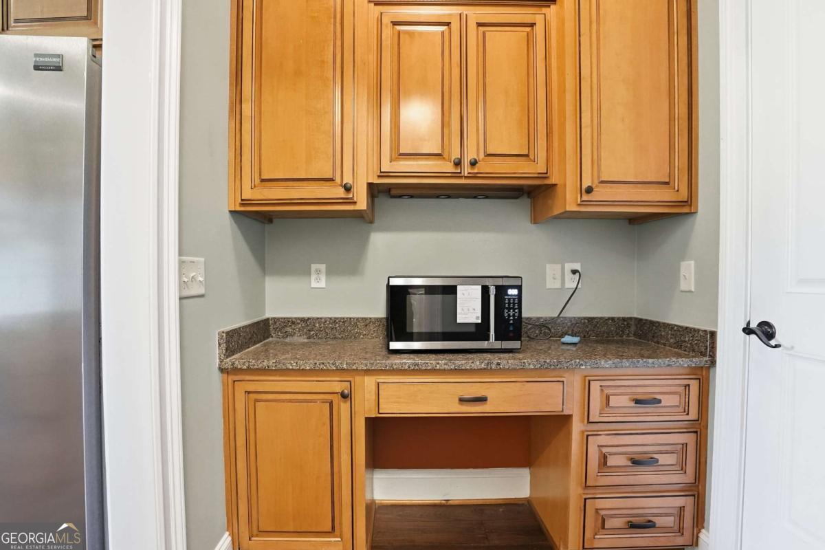 135 Stewart Street St. Simons, GA 31522 - Photo 12 of 27 a kitchen with stainless steel appliances granite countertop a stove a microwave and cabinets