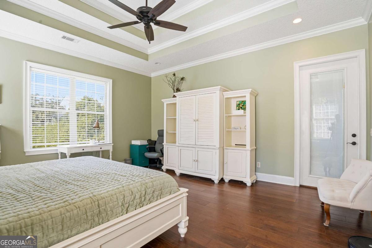 135 Stewart Street St. Simons, GA 31522 - Photo 19 of 27 a bedroom with a large bed and a chandelier