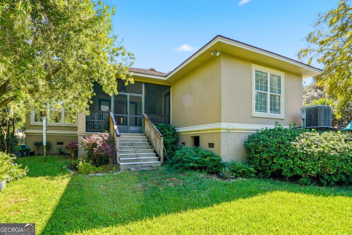 135 Stewart Street St. Simons, GA 31522 - Photo 25 of 27 a front view of a house with a yard