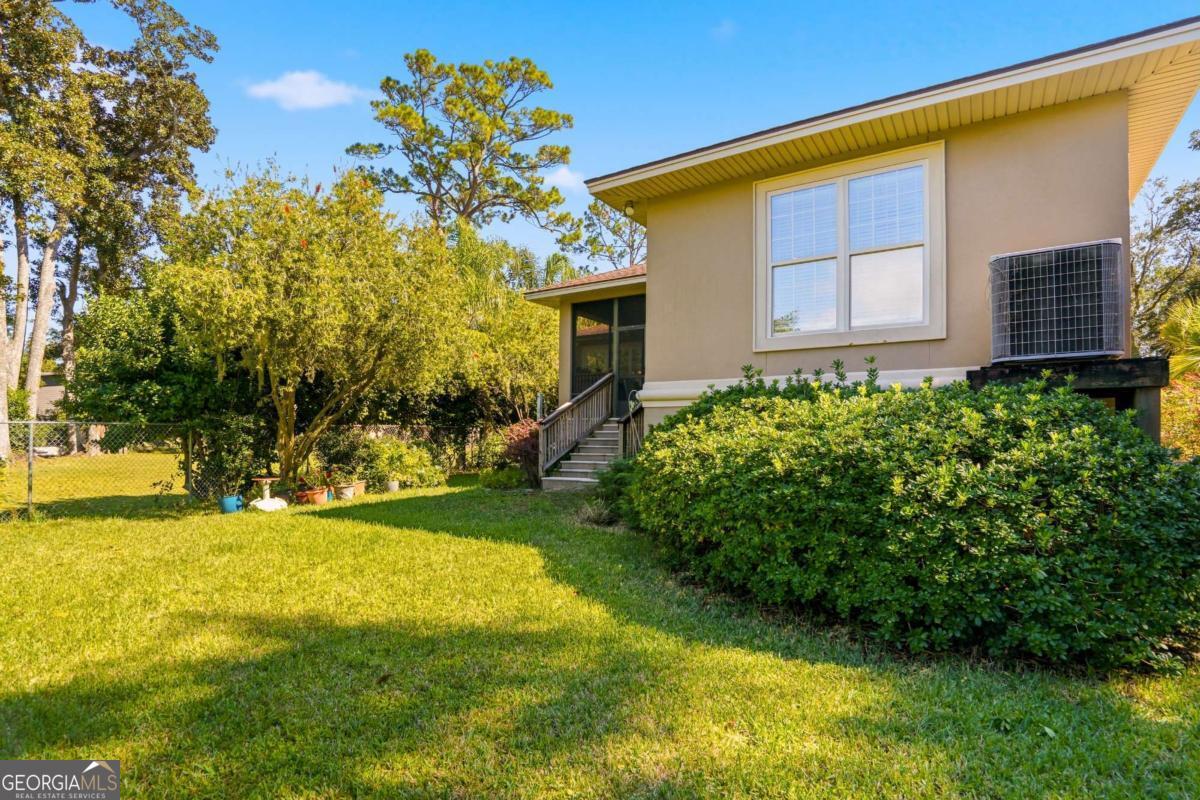 135 Stewart Street St. Simons, GA 31522 - Photo 26 of 27 a front view of a house with garden