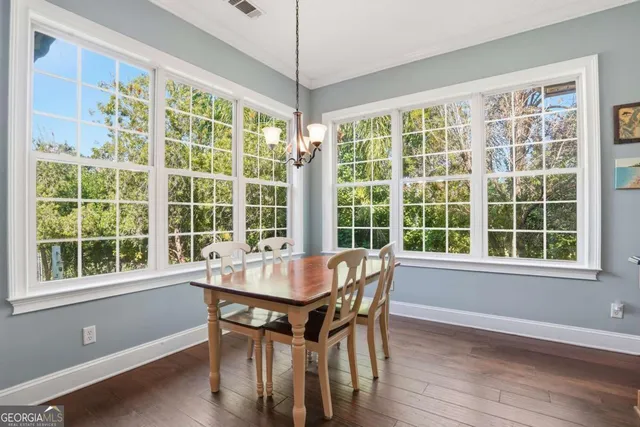 a dining room with wooden floor and windows
