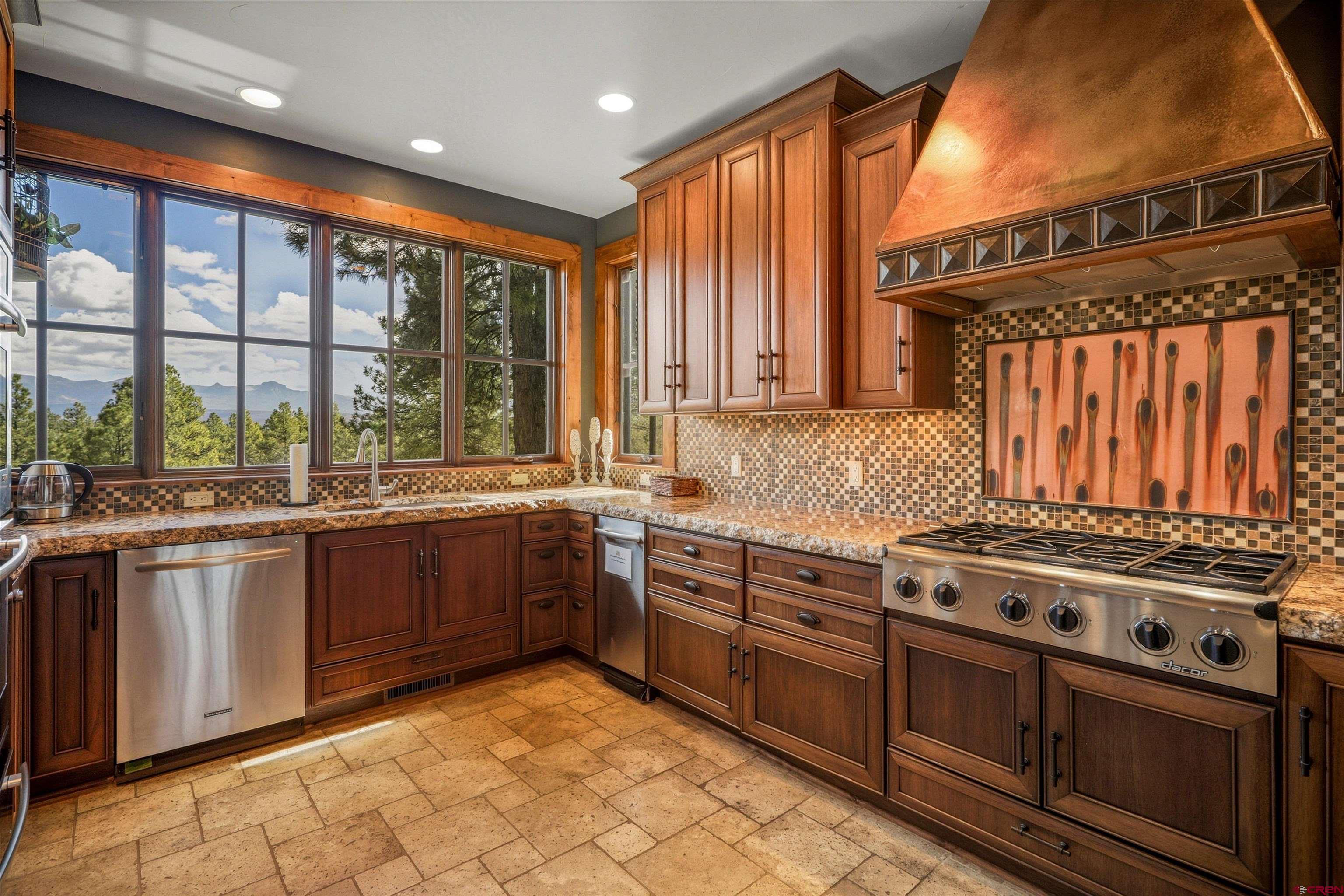 171 South Squaw Canyon Place Pagosa Springs, CO 81147 - Photo 14 of 45 a kitchen with stainless steel appliances granite countertop a stove a sink and a microwave