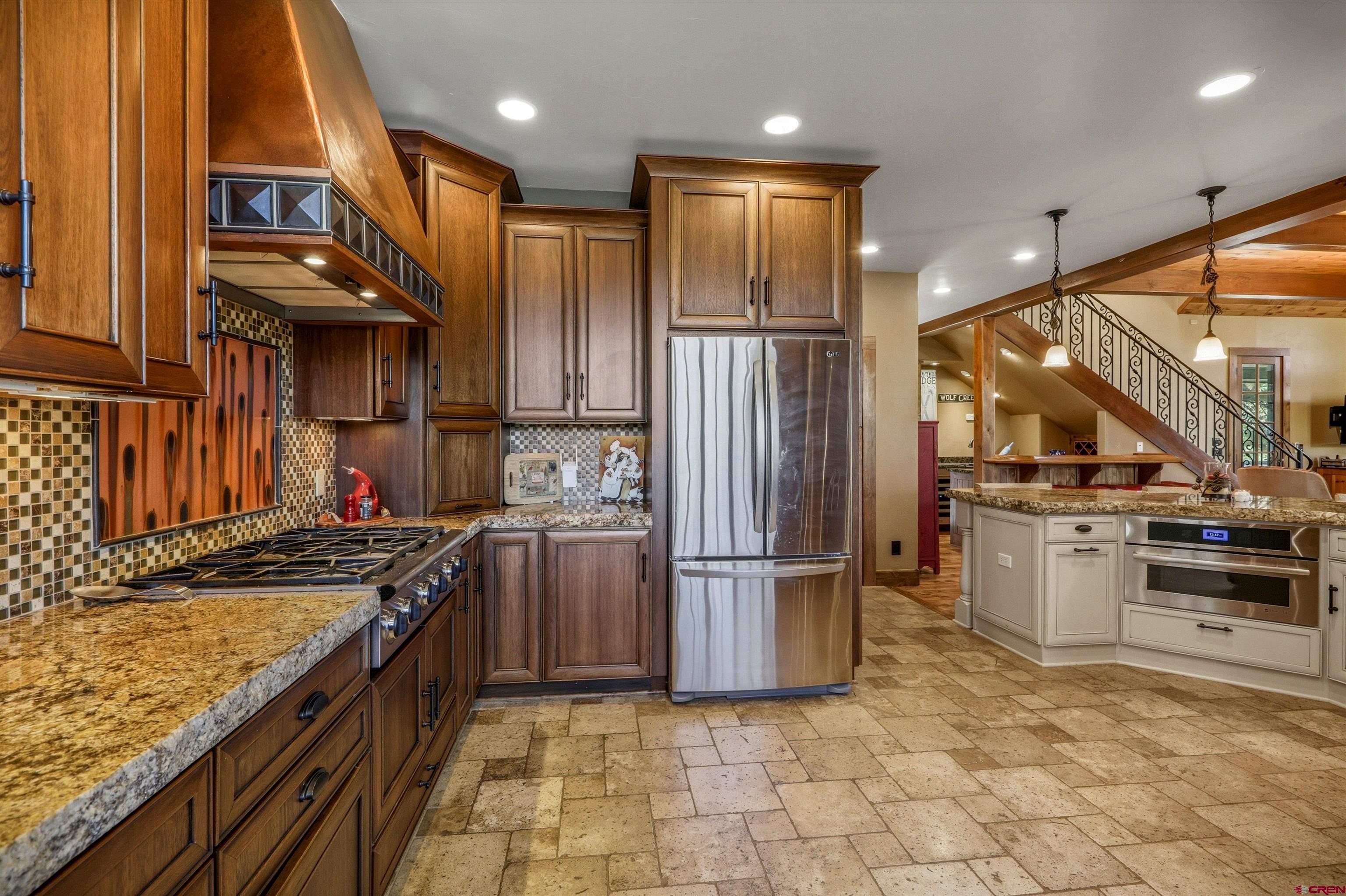 171 South Squaw Canyon Place Pagosa Springs, CO 81147 - Photo 17 of 45 a kitchen with kitchen island a counter top space a sink stainless steel appliances and cabinets
