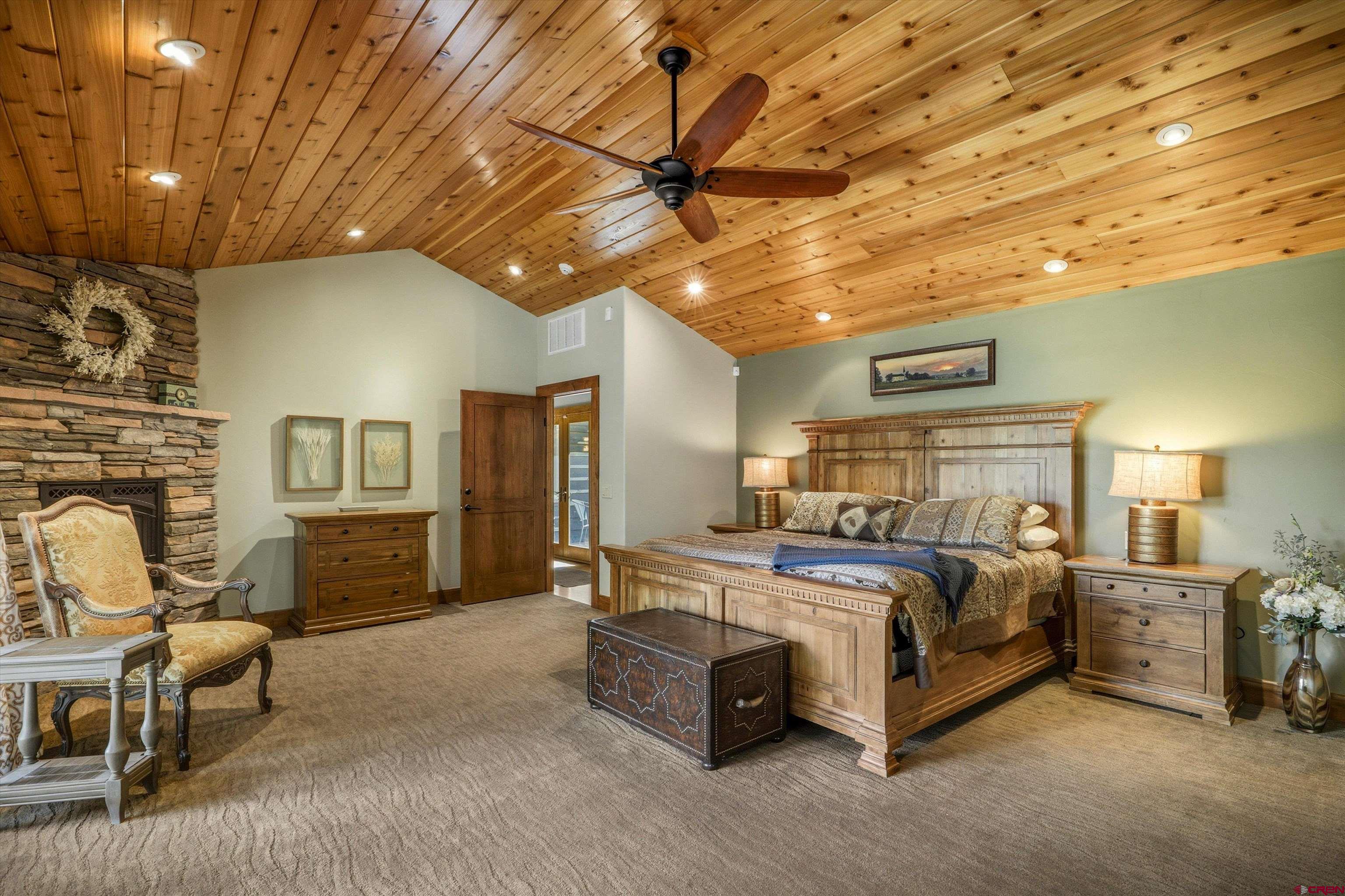 171 South Squaw Canyon Place Pagosa Springs, CO 81147 - Photo 23 of 45 a spacious bedroom with a bed and a chandelier