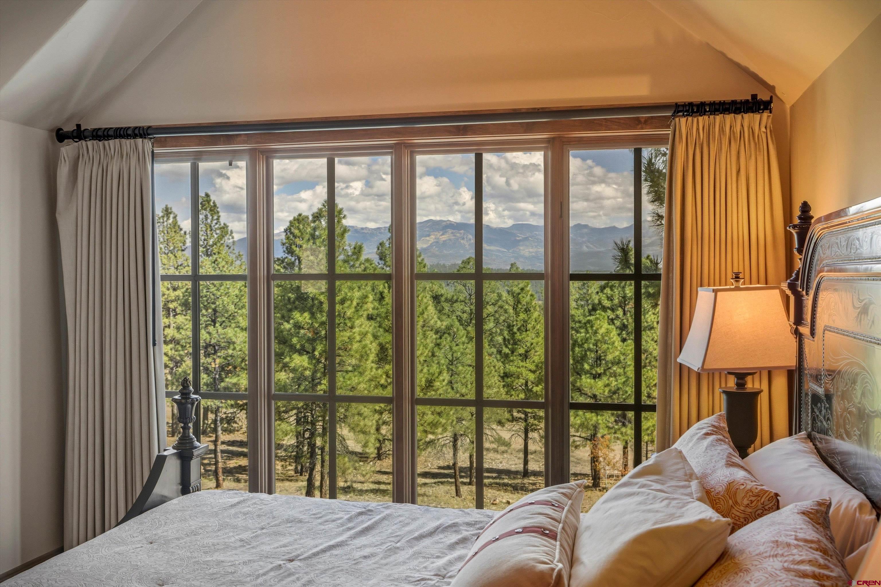 171 South Squaw Canyon Place Pagosa Springs, CO 81147 - Photo 30 of 45 a bedroom with a large bed and a large window