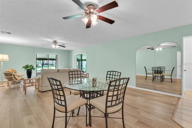 a dining room with furniture a chandelier and wooden floor