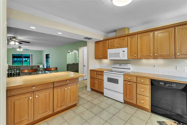 a kitchen with kitchen island granite countertop appliances cabinets and a sink