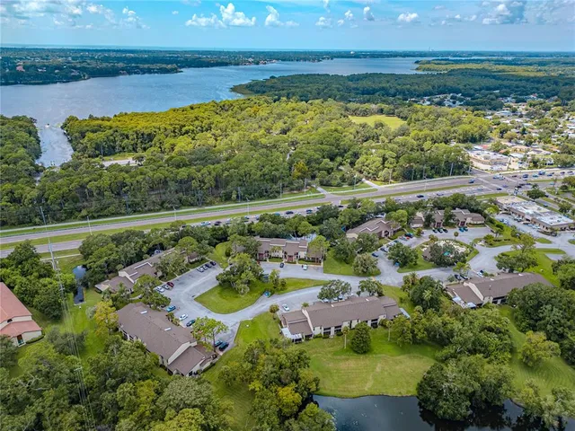 an aerial view of ocean and residential houses with outdoor space