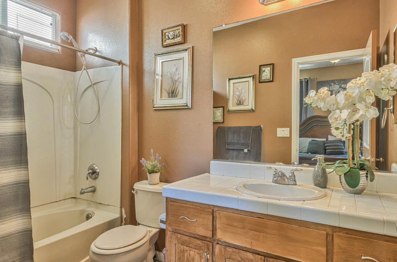 1013 Capri Way Salinas, CA 93905 - Photo 16 of 23 a bathroom with a granite countertop sink a toilet and shower