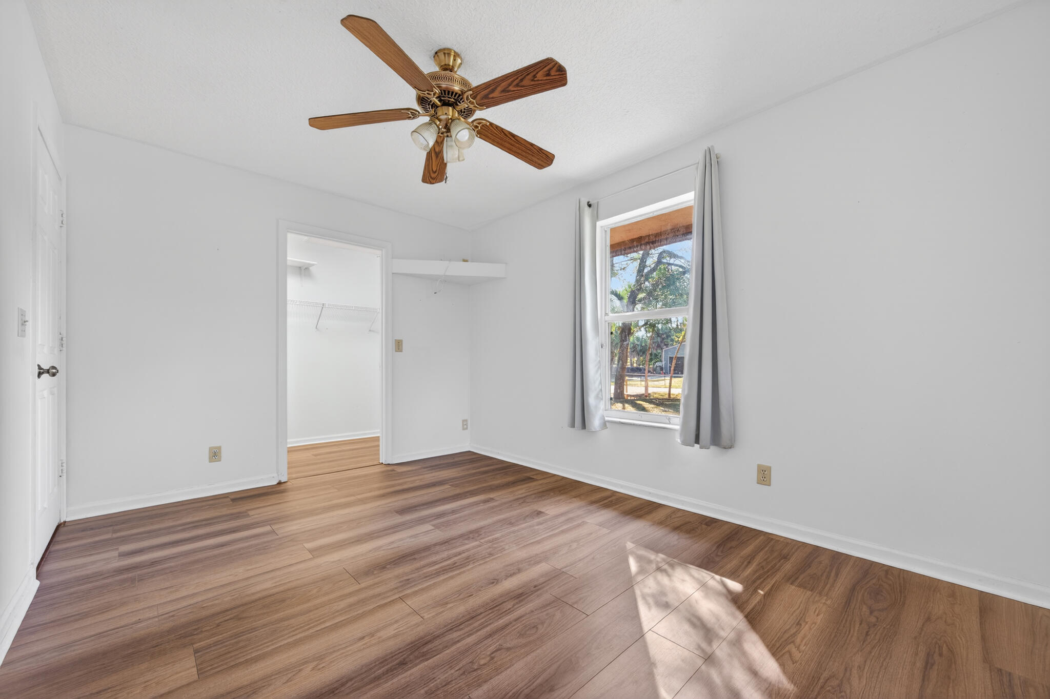 17889 62nd Road North The Acreage, FL 33470 - Photo 12 of 32 a view of an empty room with wooden floor and a window