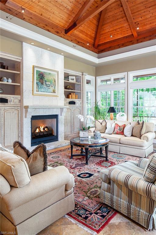 1205 Pocantico Lane Naples, FL 34110 - Photo 11 of 35 a living room with furniture a fireplace and a large window