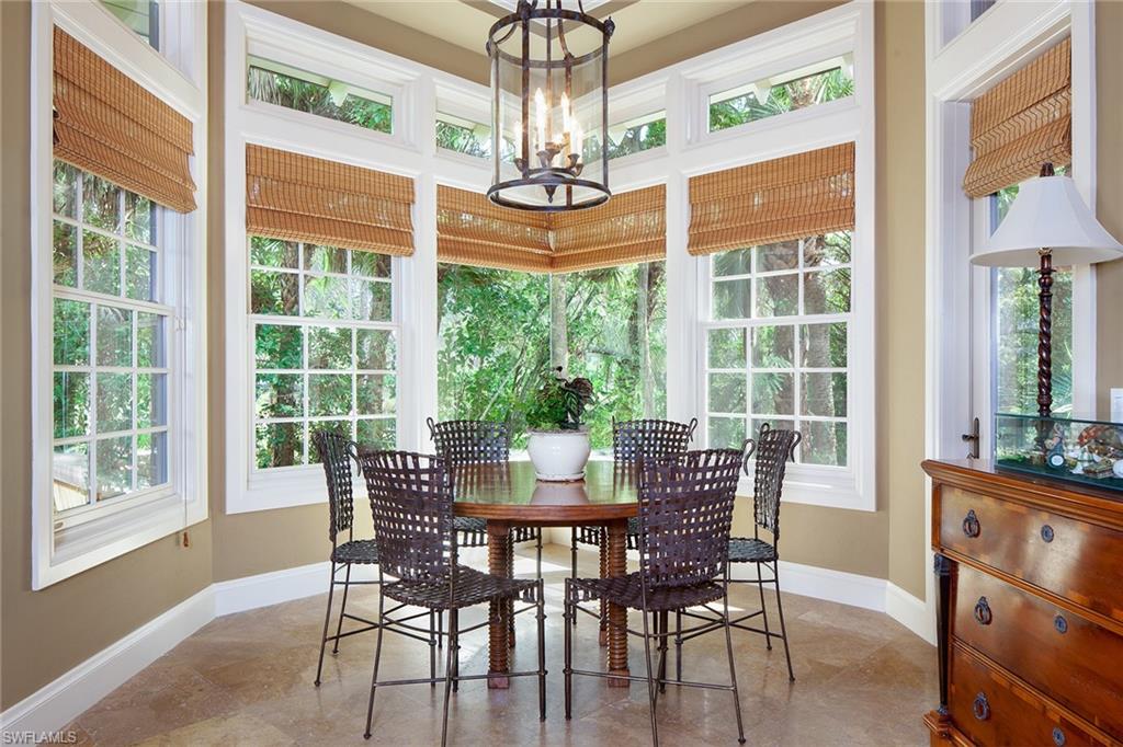 1205 Pocantico Lane Naples, FL 34110 - Photo 17 of 35 a dining room with furniture a chandelier and wooden floor