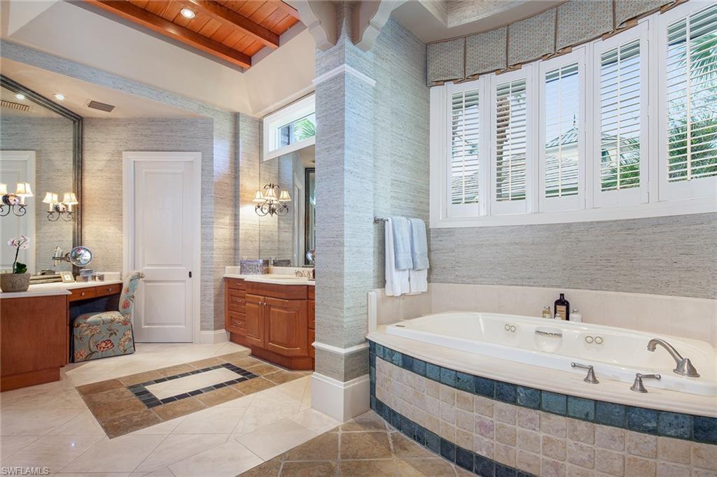1205 Pocantico Lane Naples, FL 34110 - Photo 28 of 35 a spacious bathroom with a tub sink and mirror