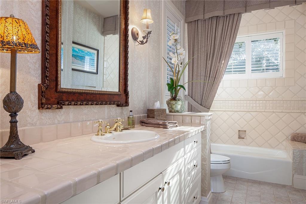1205 Pocantico Lane Naples, FL 34110 - Photo 30 of 35 a bathroom with a sink and a mirror