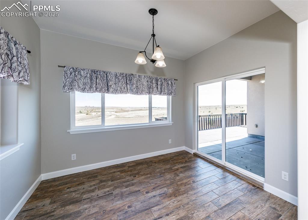 2105 Slocum Road Peyton, CO 80831 - Photo 11 of 27 a view of an empty room with wooden floor and a window