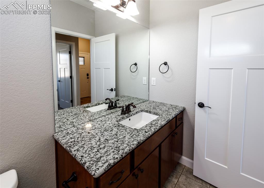 2105 Slocum Road Peyton, CO 80831 - Photo 13 of 27 a bathroom with a granite countertop sink and a mirror